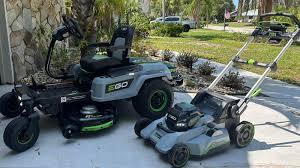 EGO Power electric zero-turn mower and push lawn mower on driveway in sunny yard