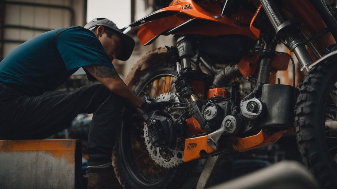 Mechanic repairing orange off-road dirt bike in workshop setting