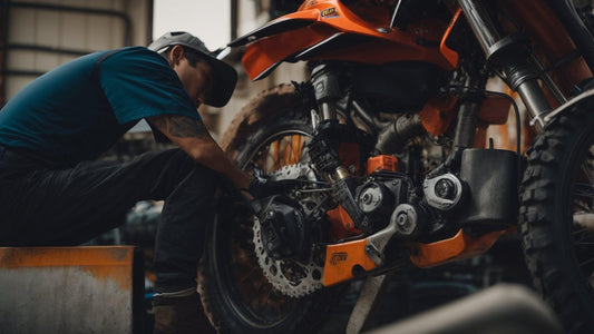 Mechanic repairing orange off-road dirt bike in workshop setting