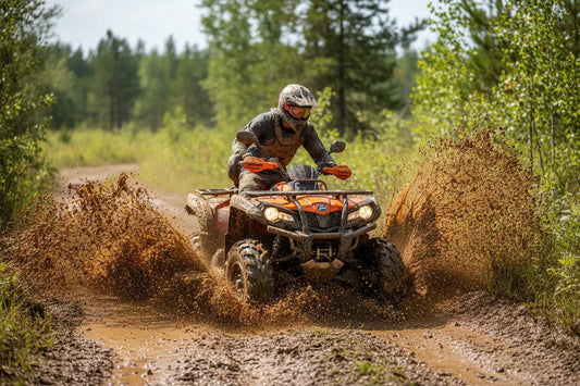 ATV rider splashing through muddy trail in the forest, off-road adventure
