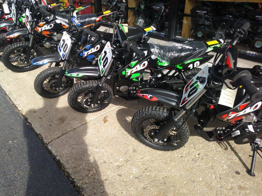 Gas-powered kids dirt bikes for beginners lined up outside on display