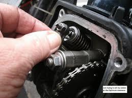 Hand adjusting 50cc 150cc 4-stroke scooter engine valve with timing chain visible