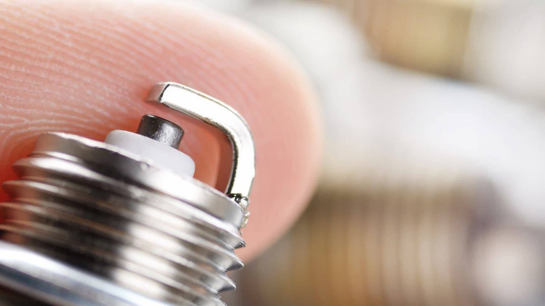 Close-up of a spark plug tip showing proper electrode gap for ATV or dirt bike engines