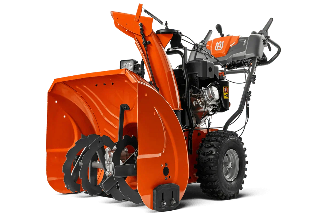 Heavy-duty orange snow blower with large augers and control panel on display