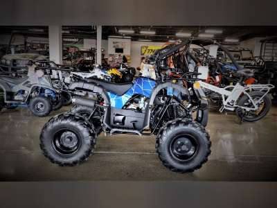 Blue 125cc kids 4-wheeler ATV with rugged tires in a showroom setting