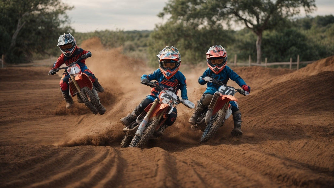 Kids riding dirt bikes on a sandy track, wearing helmets and protective motocross gear