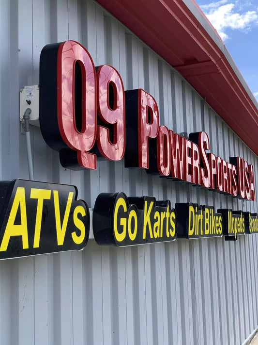 Outdoor storefront signage listing ATVs, go karts, dirt bikes, mopeds and scooters.