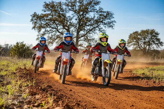 Kids riding dirt bikes with helmets and gear on a dirt trail outdoors