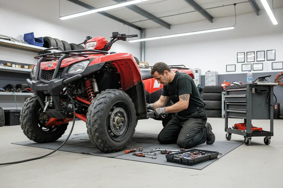 Mechanic repairing red ATV in workshop with tools and tires in the background