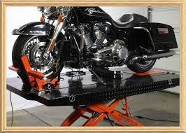 Black motorcycle on hydraulic lift in a garage during maintenance
