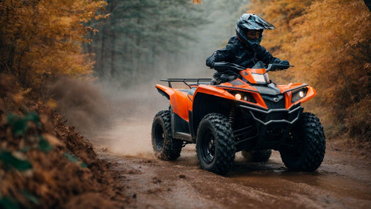 Rider on orange ATV powersports vehicle driving on a dirt trail through autumn forest