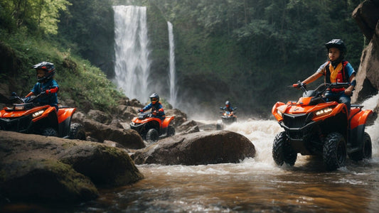 Kids riding orange all-terrain vehicles through a rocky stream by a waterfall outdoors