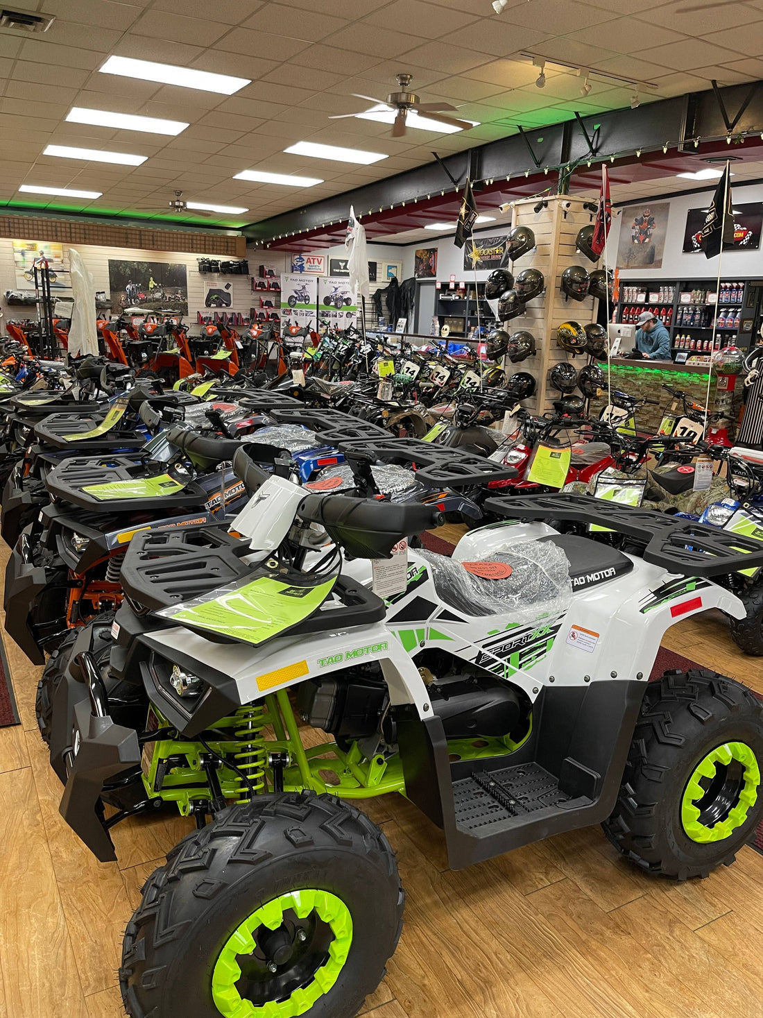 Showroom with ATVs, dirt bikes, helmets, and accessories on display for sale