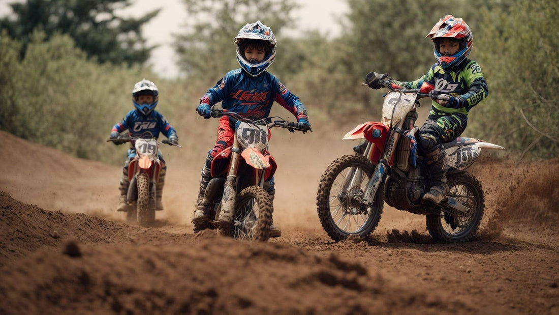 Kids riding gas powered dirt bikes on a dirt track, wearing helmets and motocross gear