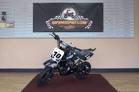 Tao Motor DB10 kids dirt bike with number 10 displayed, indoor showroom setting