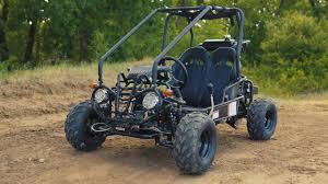 Black youth go-kart with roll cage on dirt trail, off-road vehicle for kids outdoors