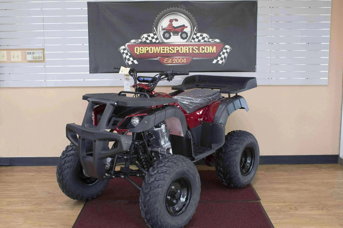 Red utility ATV with rugged tires and front grill bumper displayed indoors