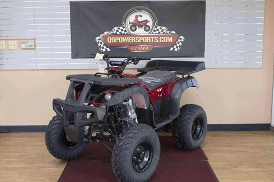 Red utility ATV with rugged tires and front grill bumper displayed indoors