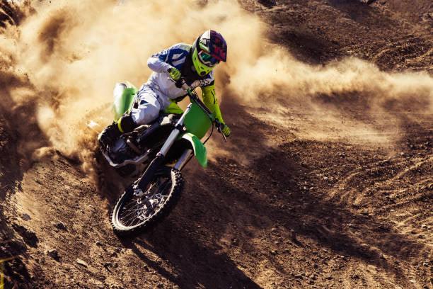 250cc dirt bike rider turning on a dusty off-road trail, kicking up dirt