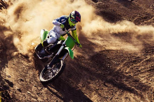 250cc dirt bike rider turning on a dusty off-road trail, kicking up dirt