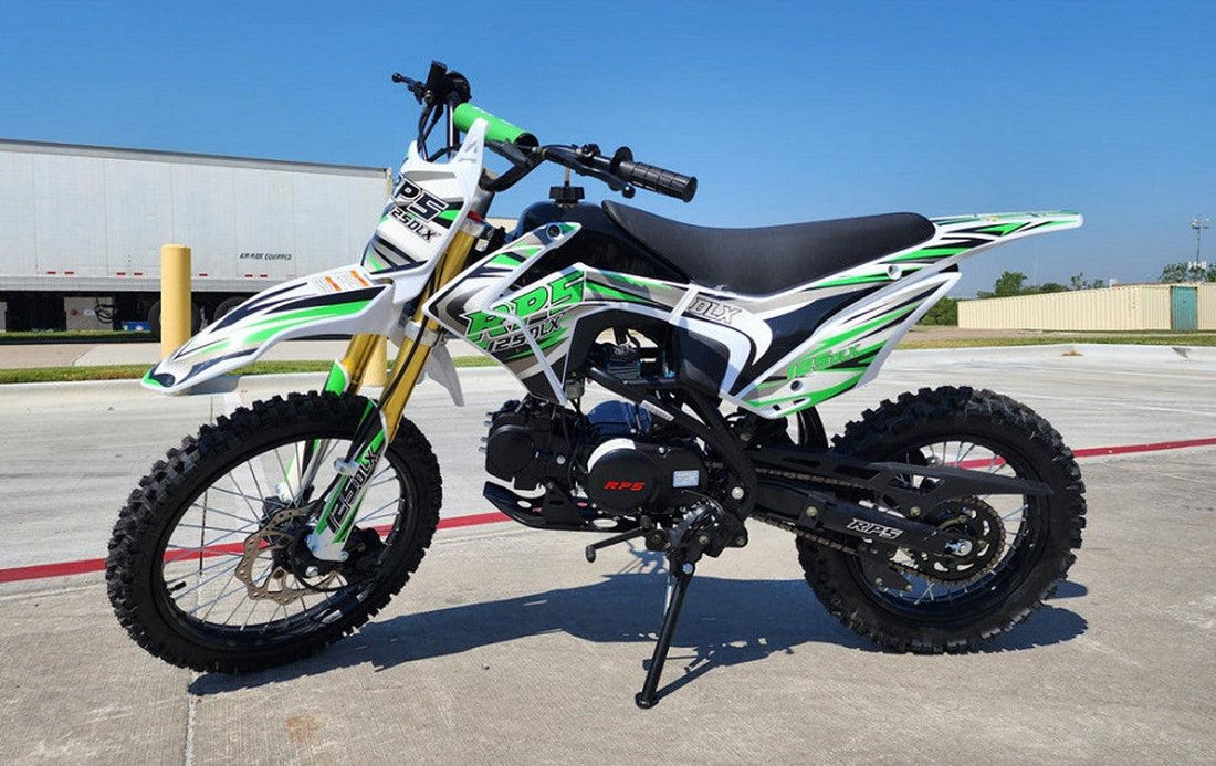 Green and white RPS 125cc DLX youth dirt bike with off-road tires parked outside on pavement