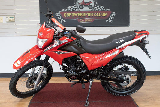 Red Hawk 250cc enduro dirt bike with knobby tires displayed indoors