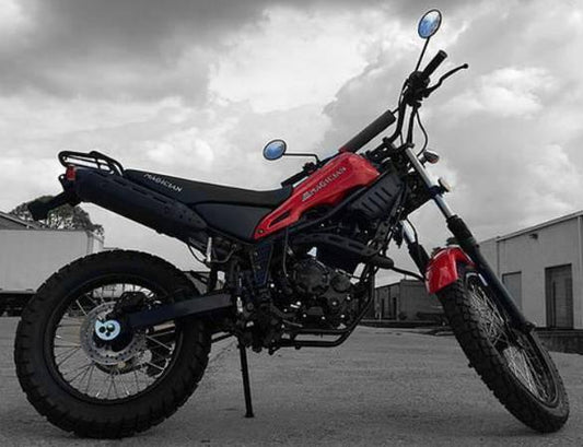 Red and black 250cc enduro dirt bike parked outdoors, knobby tires, urban setting