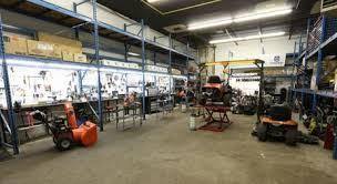 Small engine repair shop with snowblower, lawnmower, and power equipment under service