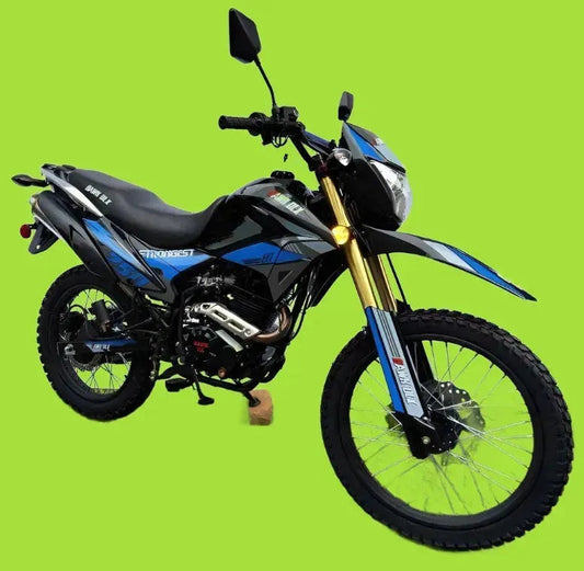 Black and blue dual sport motorcycle with knobby tires on green background