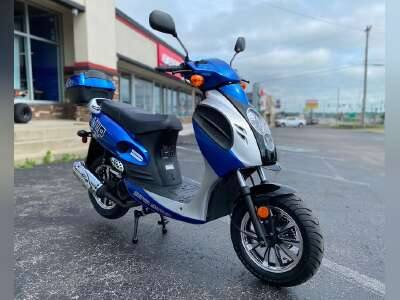 Blue and white 150cc motor scooter parked outdoors, fuel-efficient design, urban background