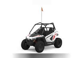 Youth side by side off-road vehicle with roll cage and flag, white and red color scheme