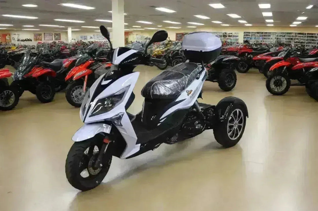 White and black three-wheeled 50cc trike scooter with storage box in a powersports showroom
