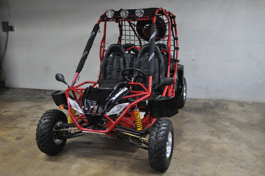 Red double seat go-kart with off-road tires, roll cage, and front LED lights in garage.