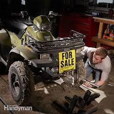 Used ATV with for sale sign in garage, man inspecting quad bike, powersports vehicle