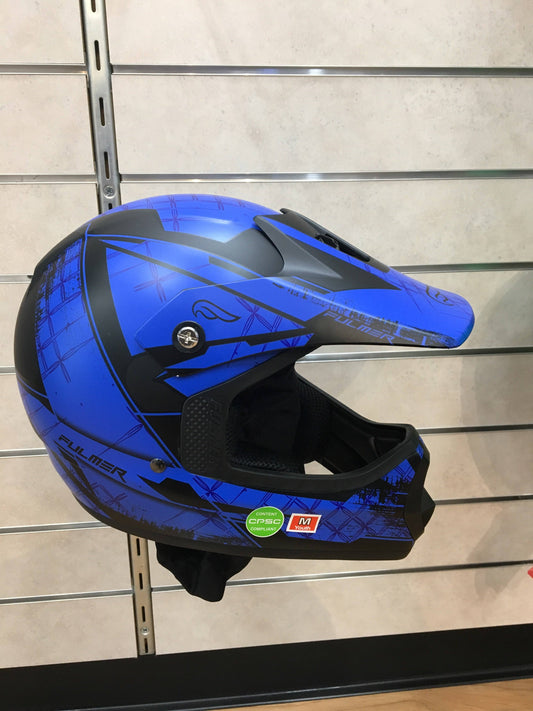 Blue youth ATV helmet with graphic design, full face protection, on display wall.